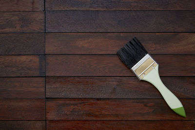 Directly above shot of paintbrush on wooden table