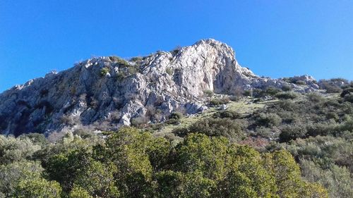 Low angle view of mountain against clear blue sky