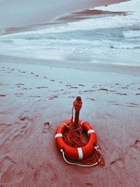 High angle view of lifesaver belt on beach against sky