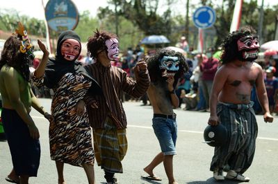 Group of people wearing costumes walking on city street