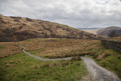 Road leading towards mountains against sky