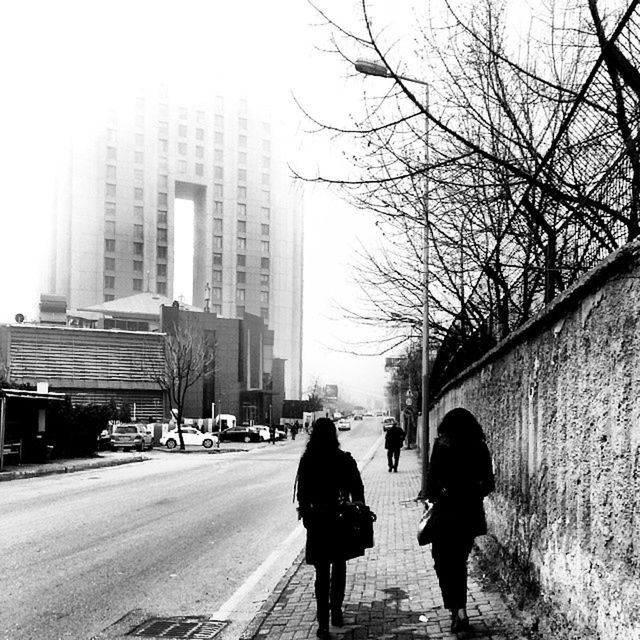 building exterior, street, architecture, built structure, walking, full length, lifestyles, city, men, transportation, rear view, road, city life, person, leisure activity, on the move, car, tree