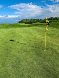 Scenic view of golf course against sky