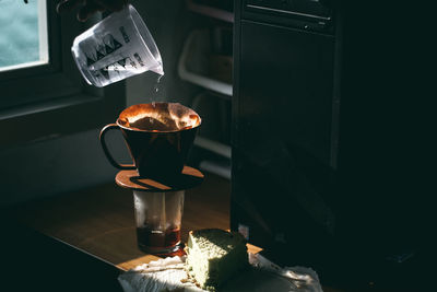 Close-up of mug pouring water in container