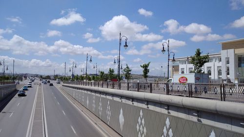 Cars on road against sky in city