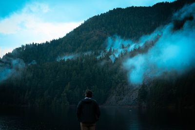Rear view of man standing against mountain