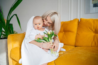 Portrait of cute girl with dog on bed at home