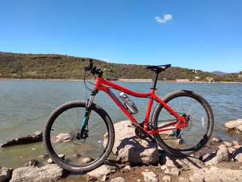 Bicycle wheel on beach against clear blue sky