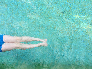 Cropped image of man lying in swimming pool
