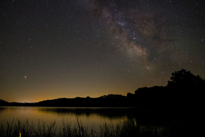 Scenic view of lake against sky at night