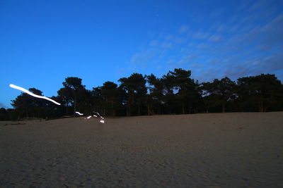 Trees on field against sky at night