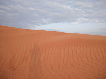 Scenic view of sand dunes against sky