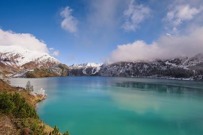 Scenic view of lake by mountains against sky