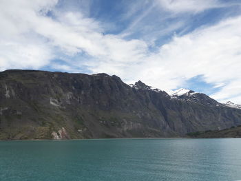 Scenic view of mountain by sea against sky