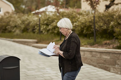 Senior woman standing near mailbox