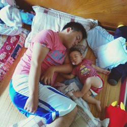 High angle view of siblings lying on floor