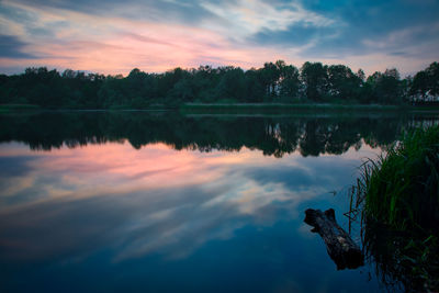 Scenic view of lake against sky at sunset