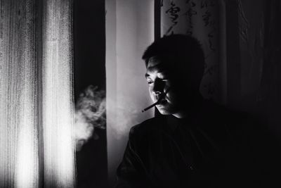 Man smoking cigarette in darkroom