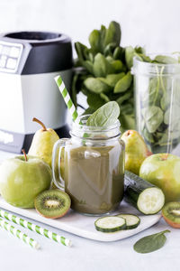 Glass jar full of green smoothie.