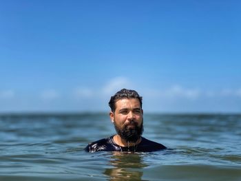 Portrait of young man in sea against sky