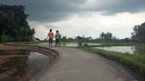 Rear view of people walking on beach