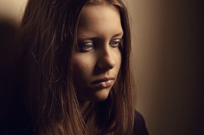 Close-up portrait of beautiful young woman over gray background