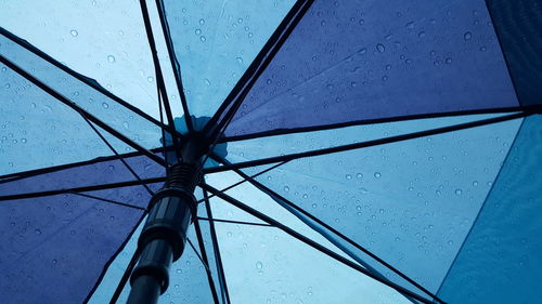 Low angle view of wet umbrella against sky