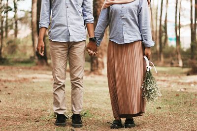 Low section of couple standing outdoors