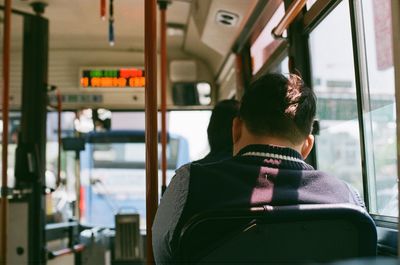 Rear view of man sitting in train