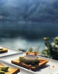 Close-up of desserts in plate with lake in background