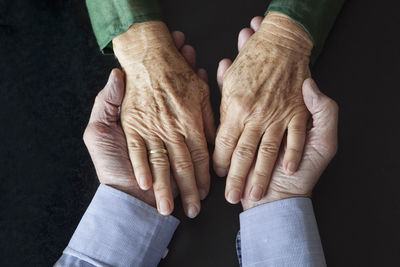 Senior couple holding hands, close-up