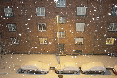 Cars parked in front of a residential building in winter