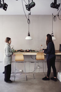Full length of woman sitting on table