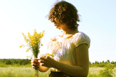 Woman standing on field against clear sky