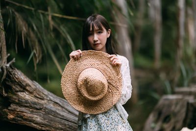 Portrait of young woman standing in forest