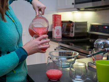 Midsection of woman holding ice cream at home