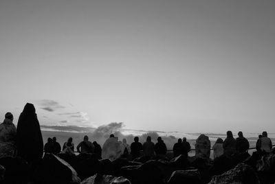 Rear view of people at haleakala crater against sky