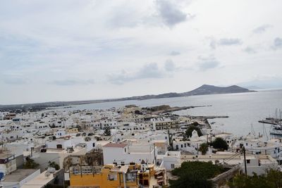 High angle view of town by sea against sky