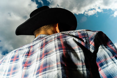 Low angle view of man with umbrella against sky