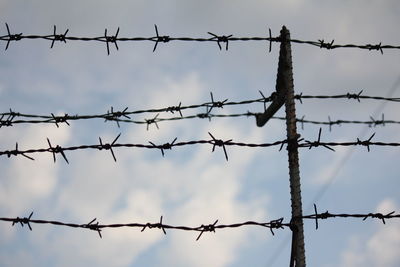 Low angle view of barbed wire against sky