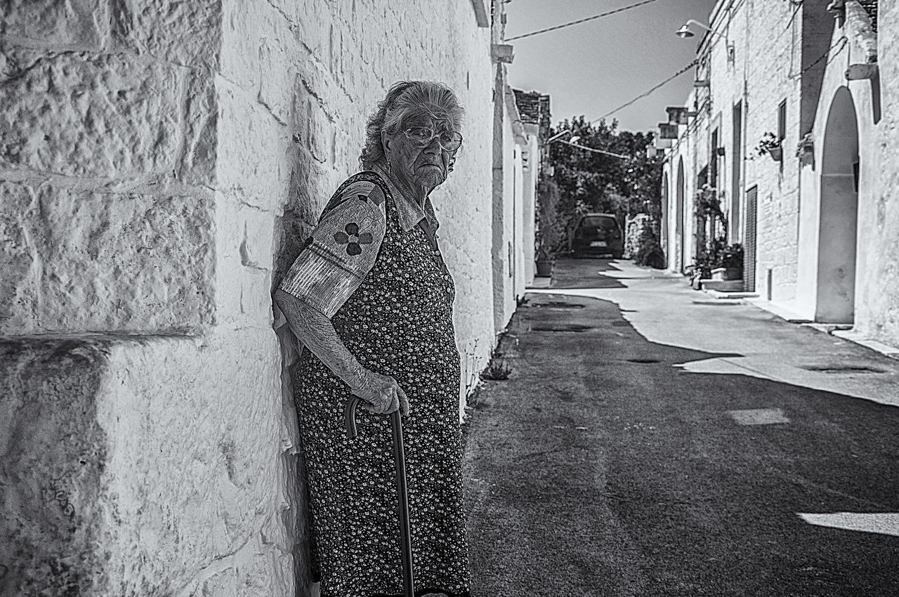 SHADOW OF WOMAN STANDING ON STREET