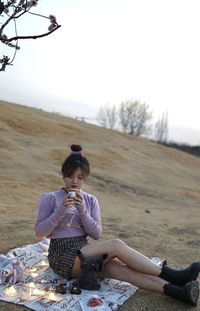 Side view of woman sitting on field