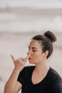 Side view of young woman looking away at beach