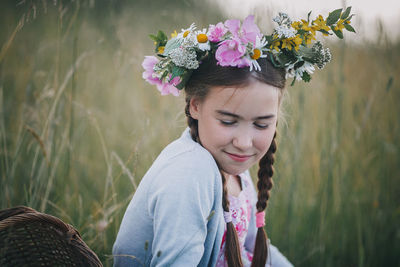 Portrait of woman with pink flowers on field