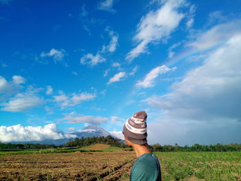 Man wearing hat while standing on agricultural field