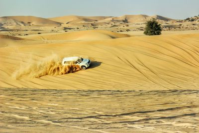 Sand dunes in desert against clear sky