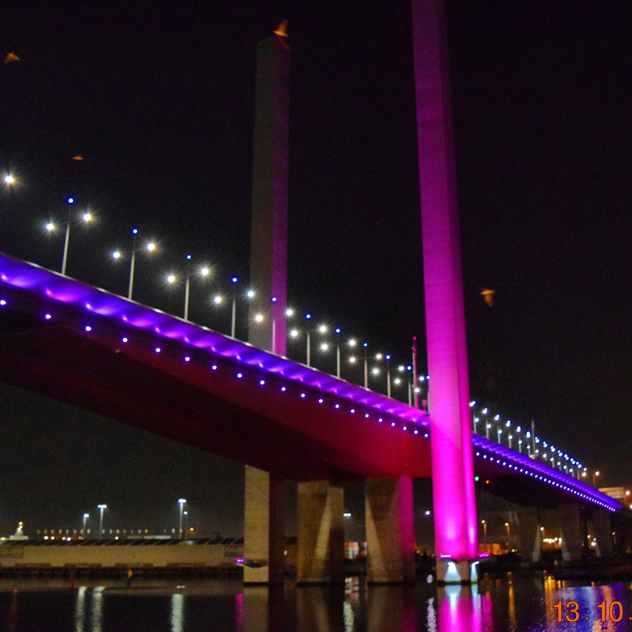 night, illuminated, architecture, built structure, reflection, building exterior, city, bridge - man made structure, lighting equipment, connection, water, river, waterfront, long exposure, low angle view, modern, sky, famous place, travel destinations, light - natural phenomenon