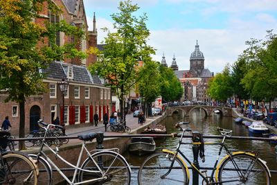 Bicycles parked on bridge over canal against basilica of st nicholas