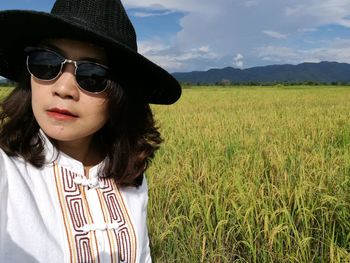 Man wearing sunglasses on field against sky