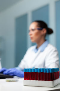 Close-up o test tubes with scientist in background